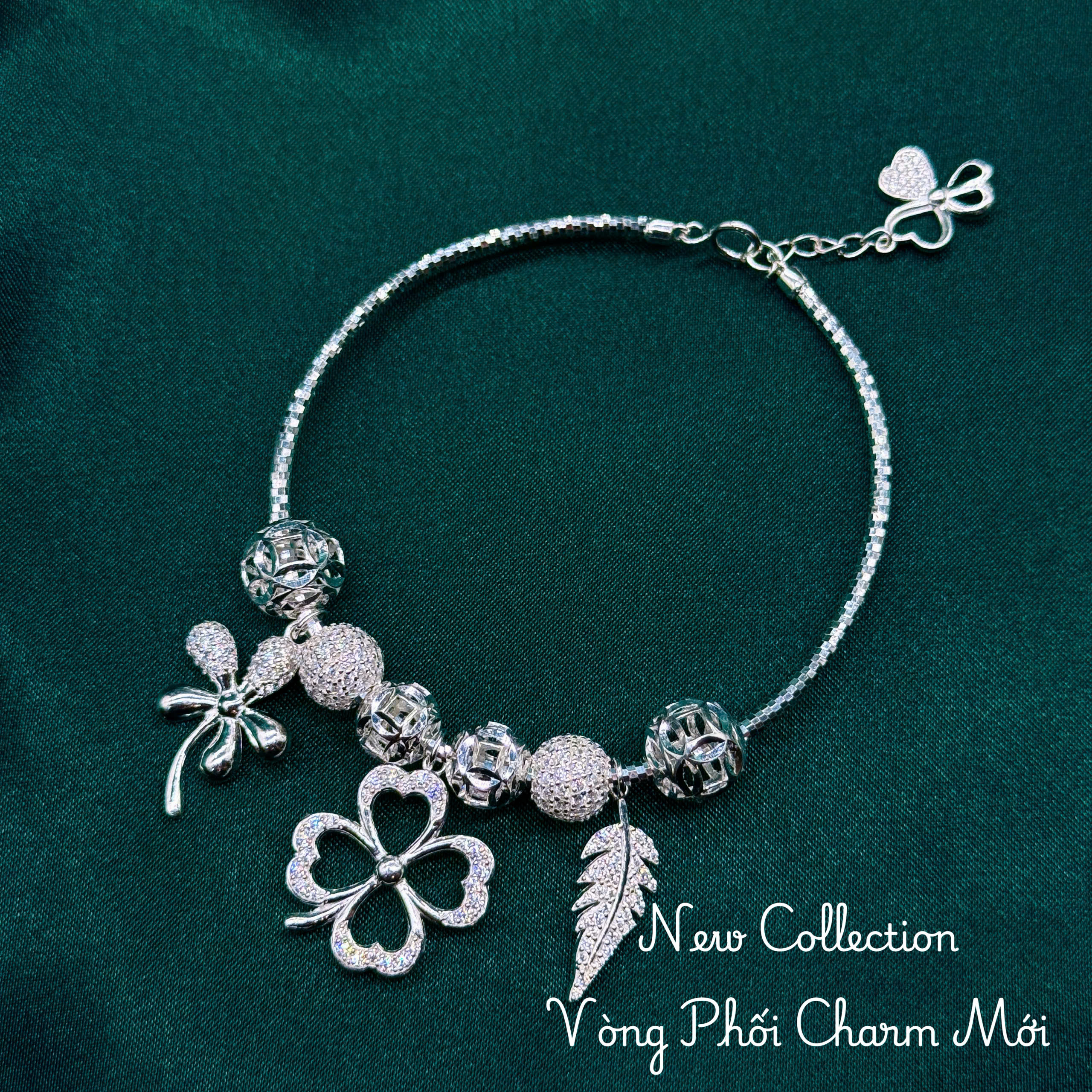vòng tay nữ charm cỏ bốn lá phối lông vũ